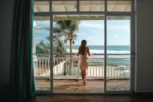 Young,Woman,Standing,On,The,Balcony,And,Looking,At,The